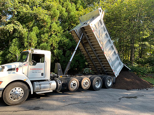 Photo of Gainesville Topsoil and Excavation dump truck delivering premium organic compost